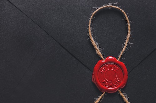 Red Wax seal with the writing Notary public on a black envelope.